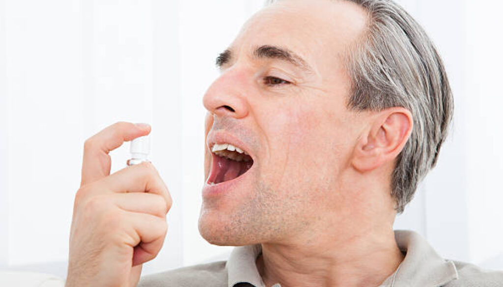 Close-up of a man applying Fresh breath spray